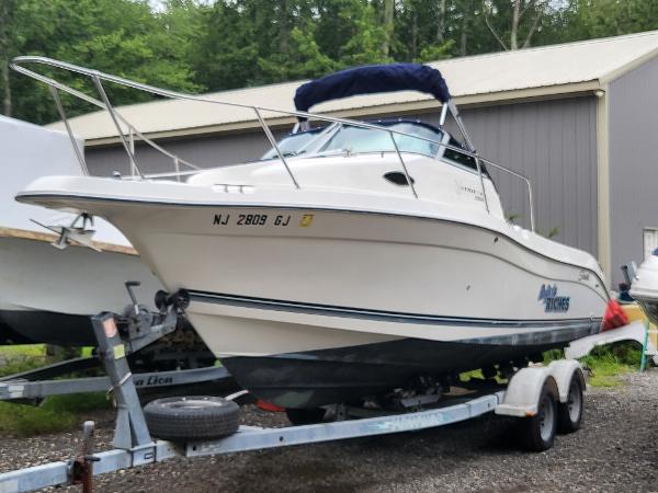 Seaswirl 2300 Walkaround 1998 Seaswirl 2300 Walkaround boat on trailer, parked outdoors near a building.