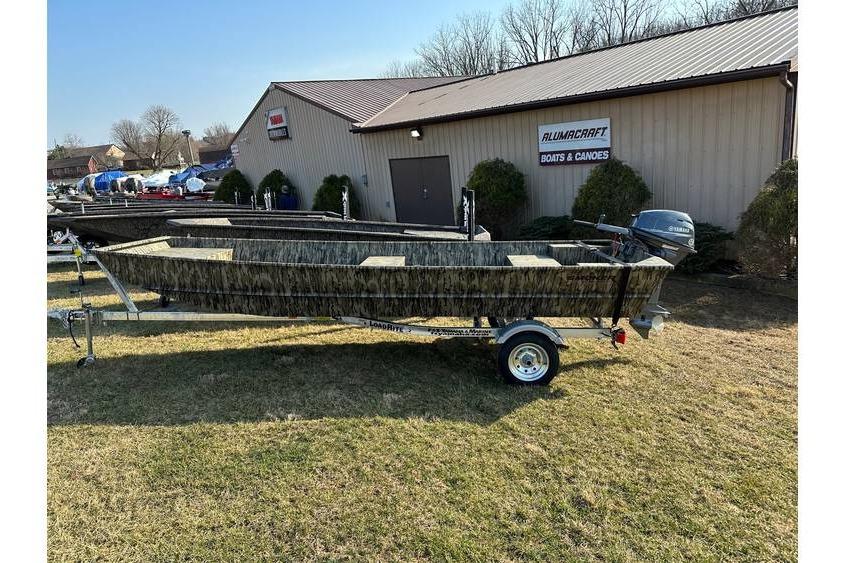 Smoker Craft 1448 jon boat, 20" transom w/ trailer & Yamaha 9.9 hp 2025 Smoker Craft Jon Boat 1448 on trailer outside Alumacraft dealership.