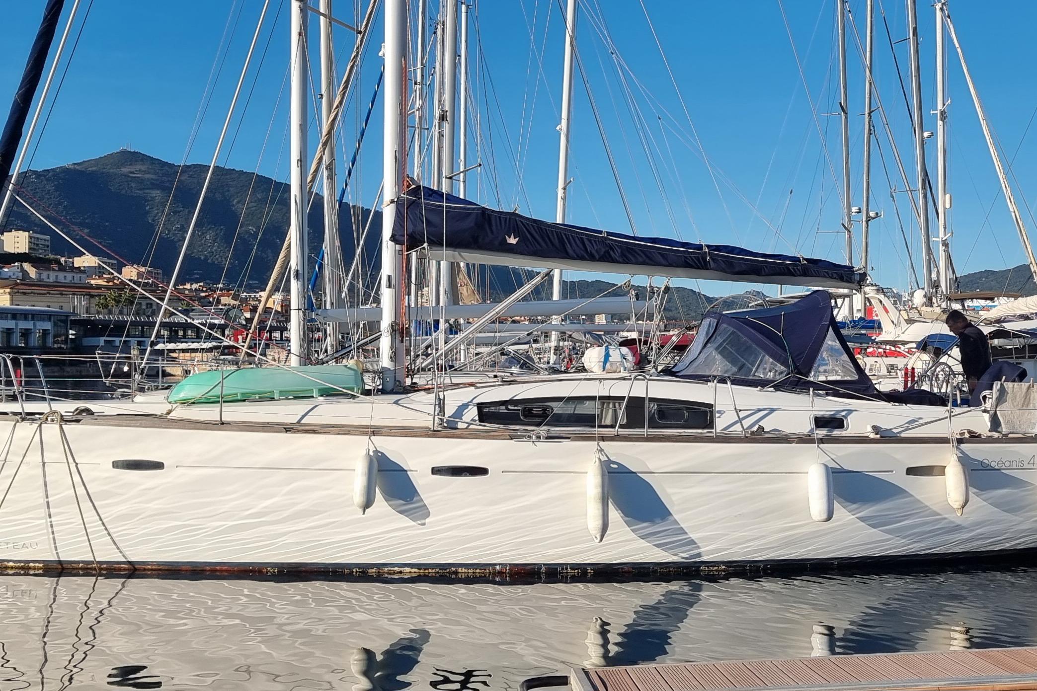 Beneteau Oceanis 43 2008 Beneteau Oceanis 43 sailboat docked in a marina with mountainous backdrop.