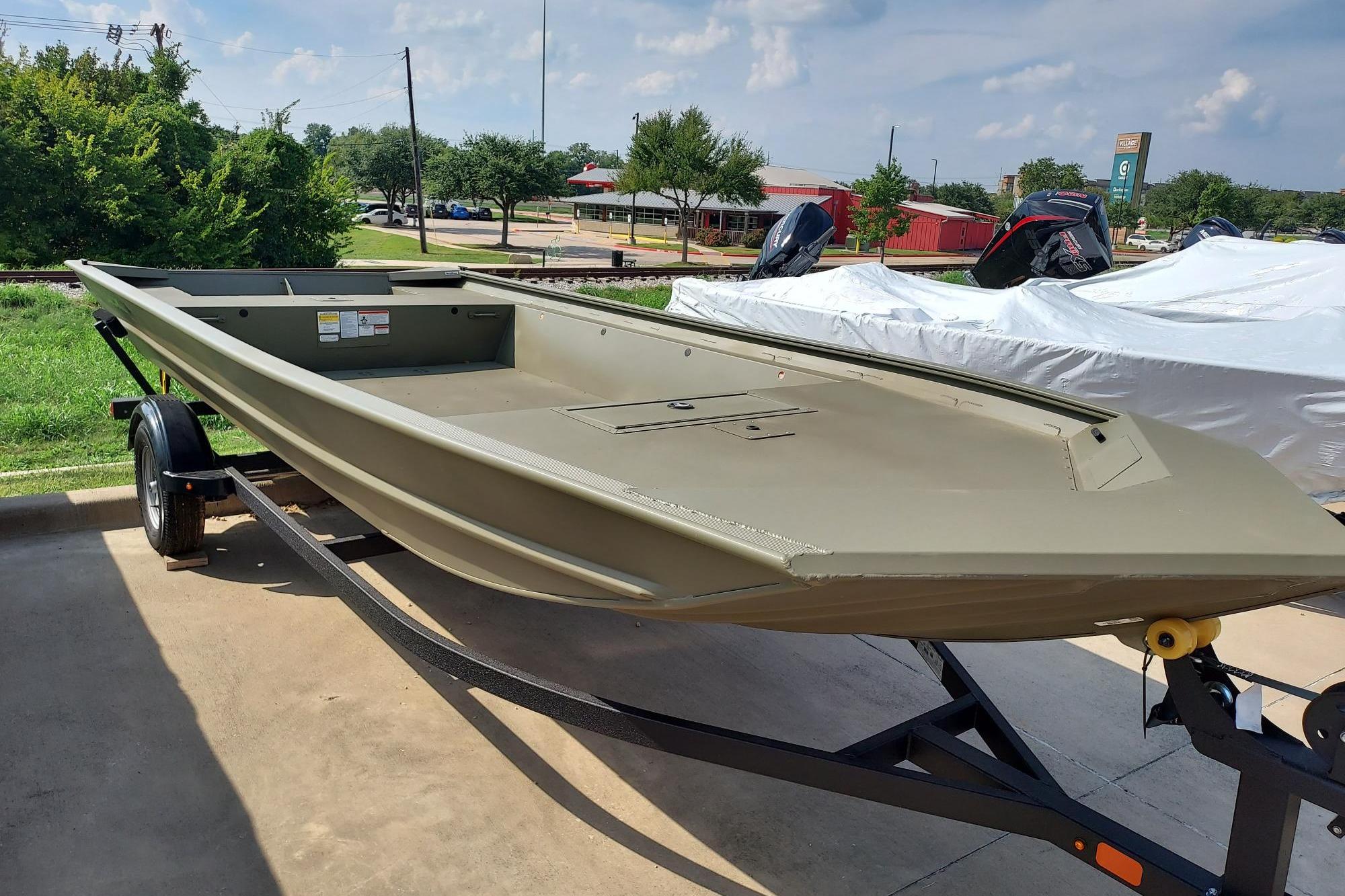 Tracker Grizzly 1860 Utility 2025 Tracker Grizzly 1860 Utility boat on trailer, parked outdoors on a sunny day.