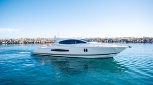 Lazzara LSX 75 2009 Lazzara LSX 75 yacht cruising on clear blue water near rocky shoreline.