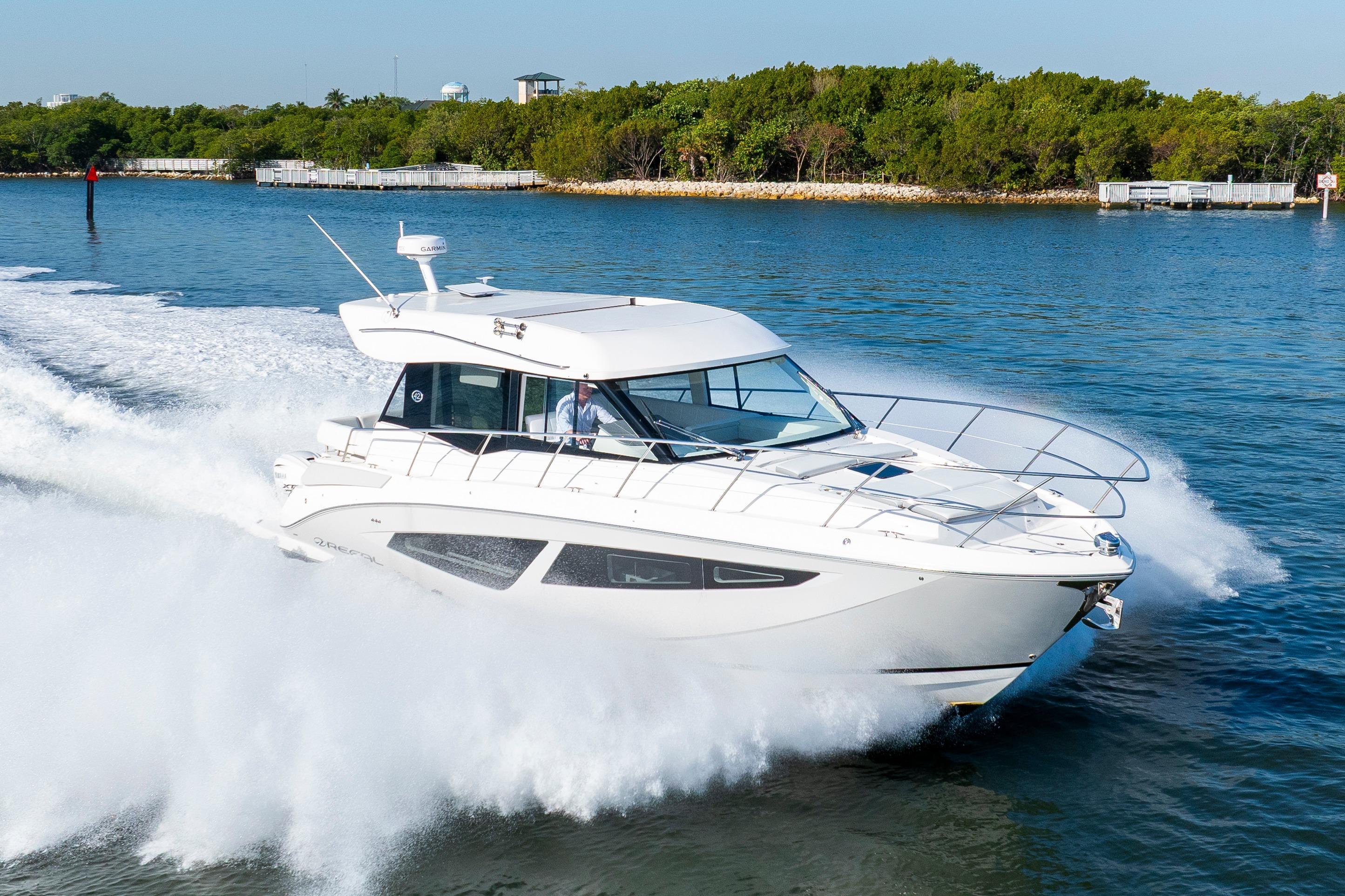 Regal 42 XO 2024 Regal 42 XO yacht cruising swiftly on a scenic waterway.