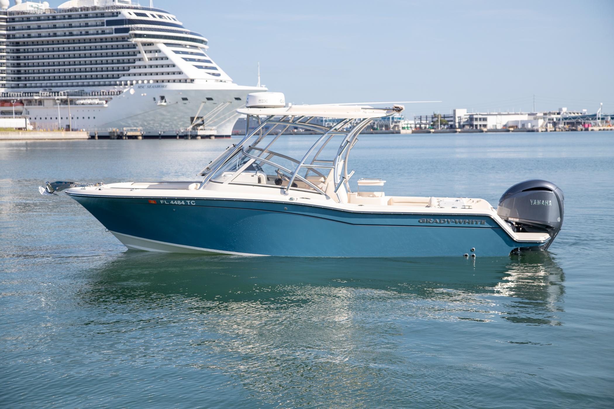 Grady-White Freedom 235 2022 Grady-White Freedom 235 boat on calm water, with a cruise ship in the background.