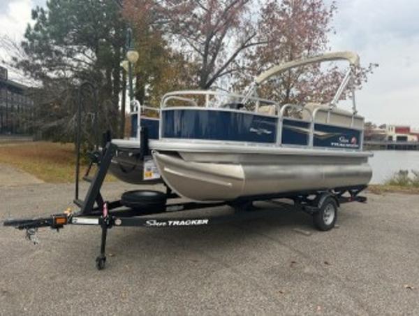 Sun Tracker Bass Buggy 16 XL Select 2025 Sun Tracker Bass Buggy 16 XL Select pontoon boat on trailer, parked outdoors.