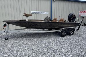 Xpress H20C Crappie 2026 Xpress H20C boat on trailer, parked on gravel, near Andalusia Marine building.