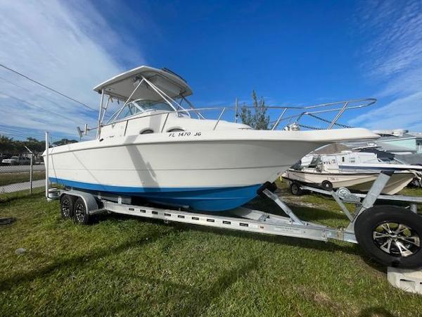 Pro-Line 27 Express 1996 Pro-Line 27 Express boat on trailer, parked on grass under clear blue sky.