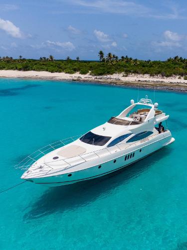Azimut 68E 2005 Azimut 68E yacht anchored in clear turquoise waters near a tropical beach.