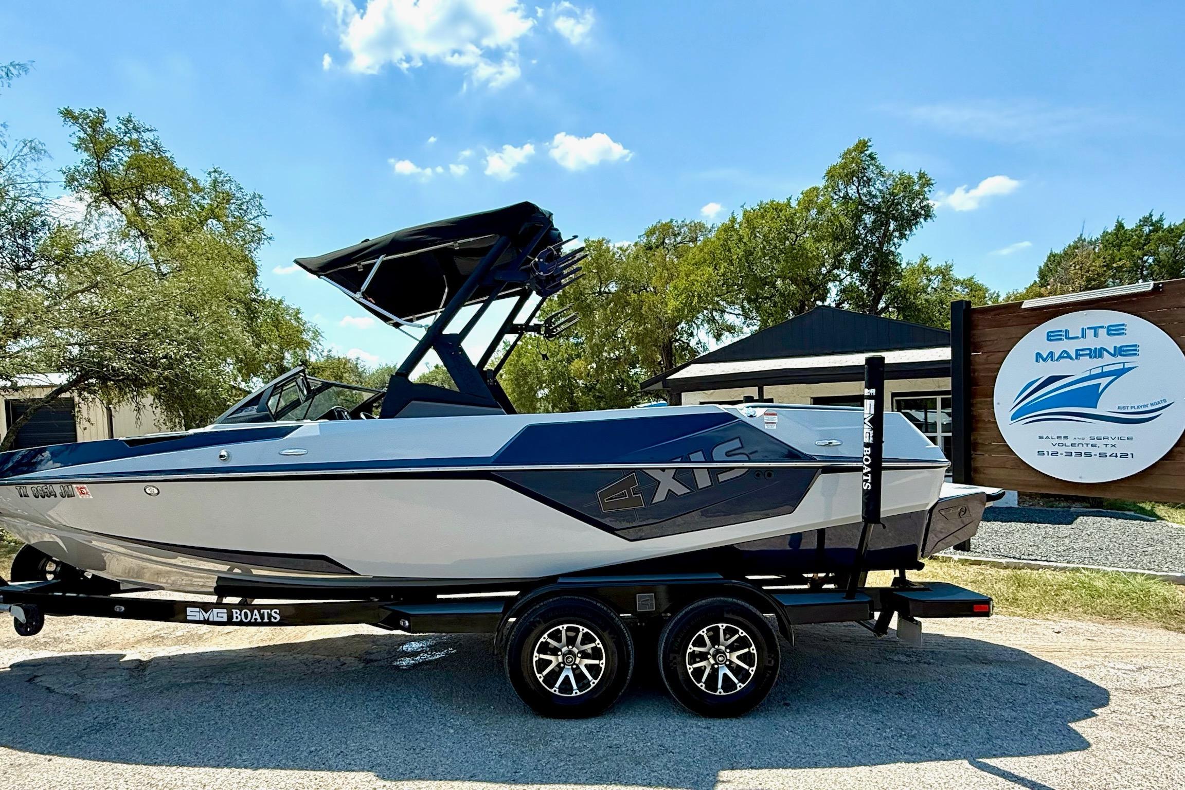 Axis T22 2021 Axis T22 boat on trailer at Elite Marine dealership under clear blue sky.