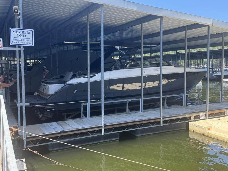 Cobalt R35 2026 Cobalt R35 boat docked in a covered marina, "Members Only" sign visible.
