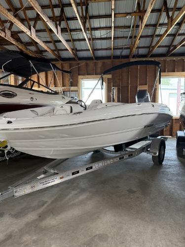 Stingray 182SC 2025 Stingray 182SC boat on trailer in a wooden garage.