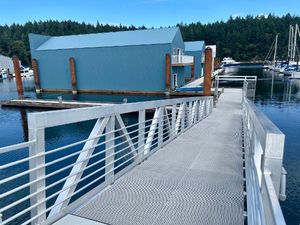 Custom 80 Foot Boathouse Modern 80-foot boathouse with blue exterior, docked in a serene marina setting.