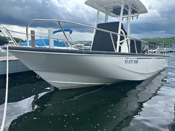 Boston Whaler 210 Montauk 2022 Boston Whaler 210 Montauk boat docked on a calm lake under cloudy skies.