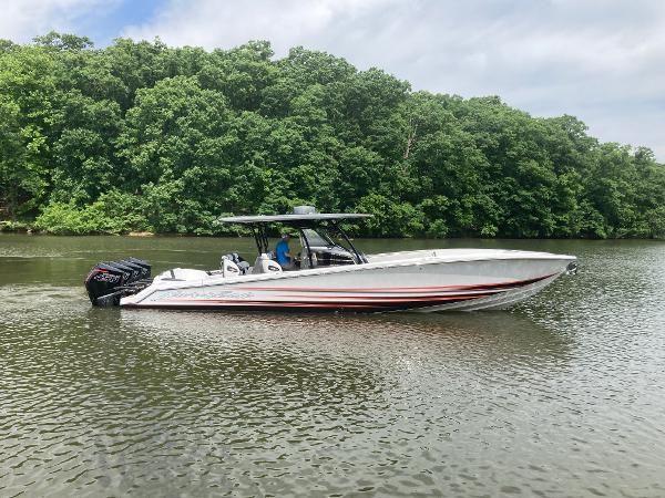 Nor-Tech 390 Sport 2024 Nor-Tech 390 Sport boat on a calm river with lush green trees.