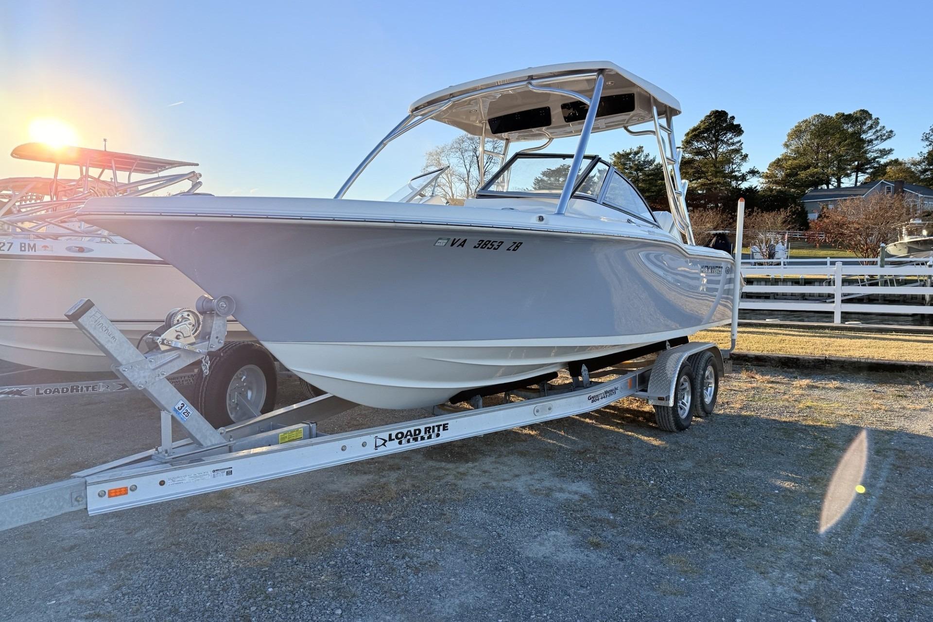 Key West 239 DFS 2024 Key West 239 DFS boat on trailer, sunlit, parked outdoors.