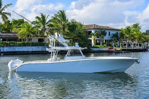 Yellowfin 42 Offshore 2021 Yellowfin 42 boat on a calm waterway, surrounded by palm trees and waterfront homes.