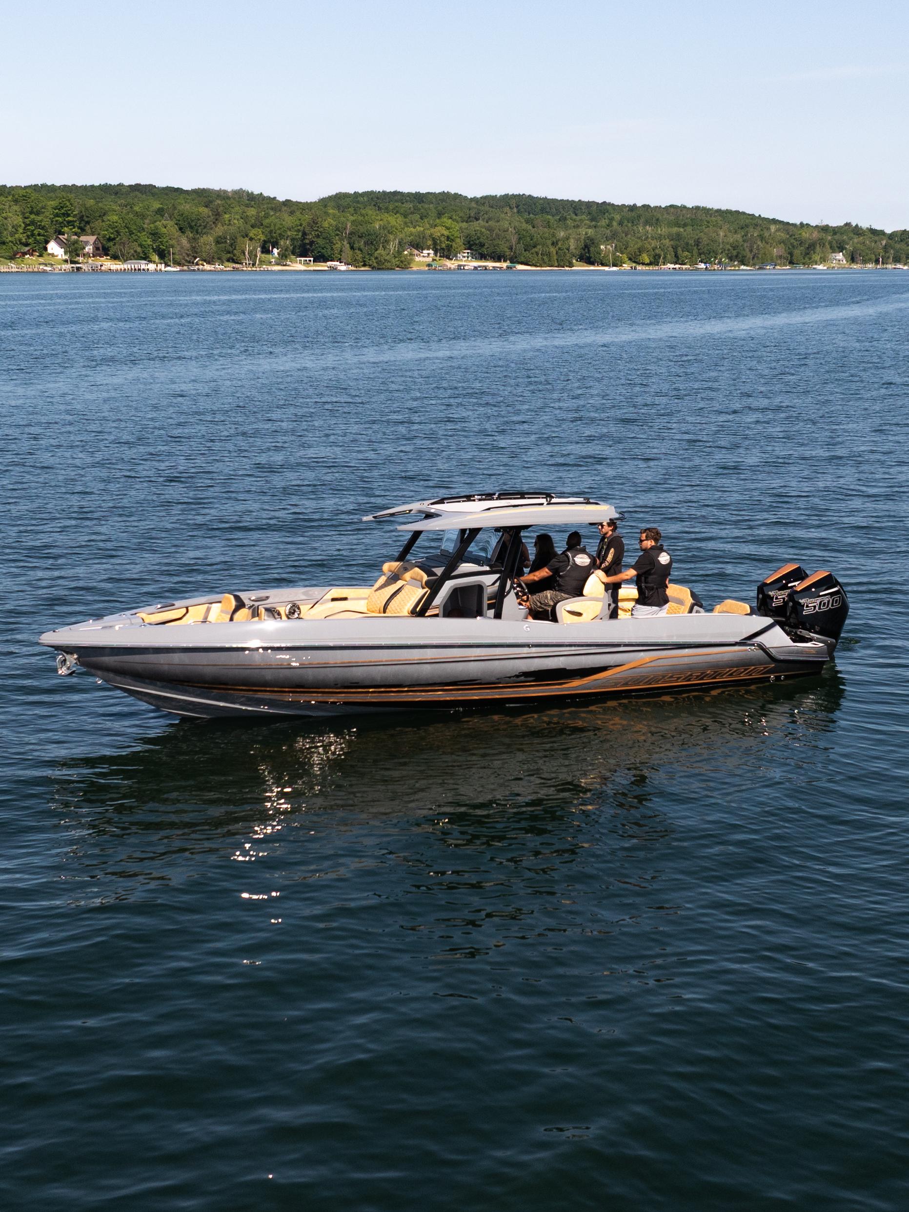 Sunsation 32 CCX 2025 Sunsation 32 CCX boat cruising on a calm lake with passengers onboard.