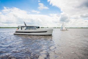 Super Lauwersmeer Discovery 46 OC Long Roof 2028 Super Lauwersmeer Discovery 46 OC Long Roof yacht on a serene lake under a cloudy sky.
