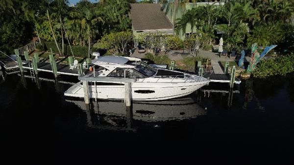 Regal 42 Sport Coupe 2017 Regal 42 Sport Coupe docked near lush greenery.