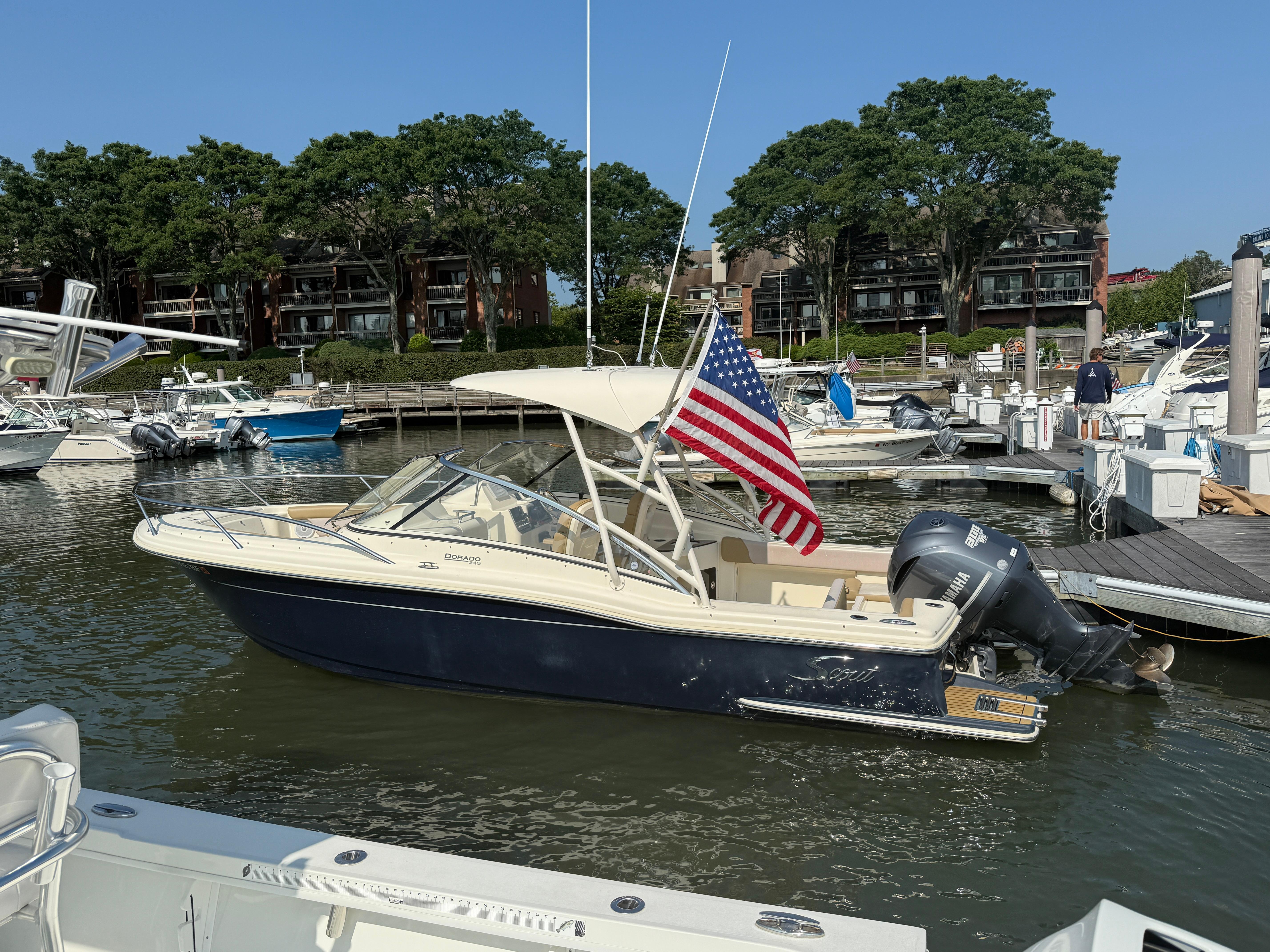 Scout 245 Dorado 2014 Scout 245 Dorado boat docked with American flag, surrounded by other boats.