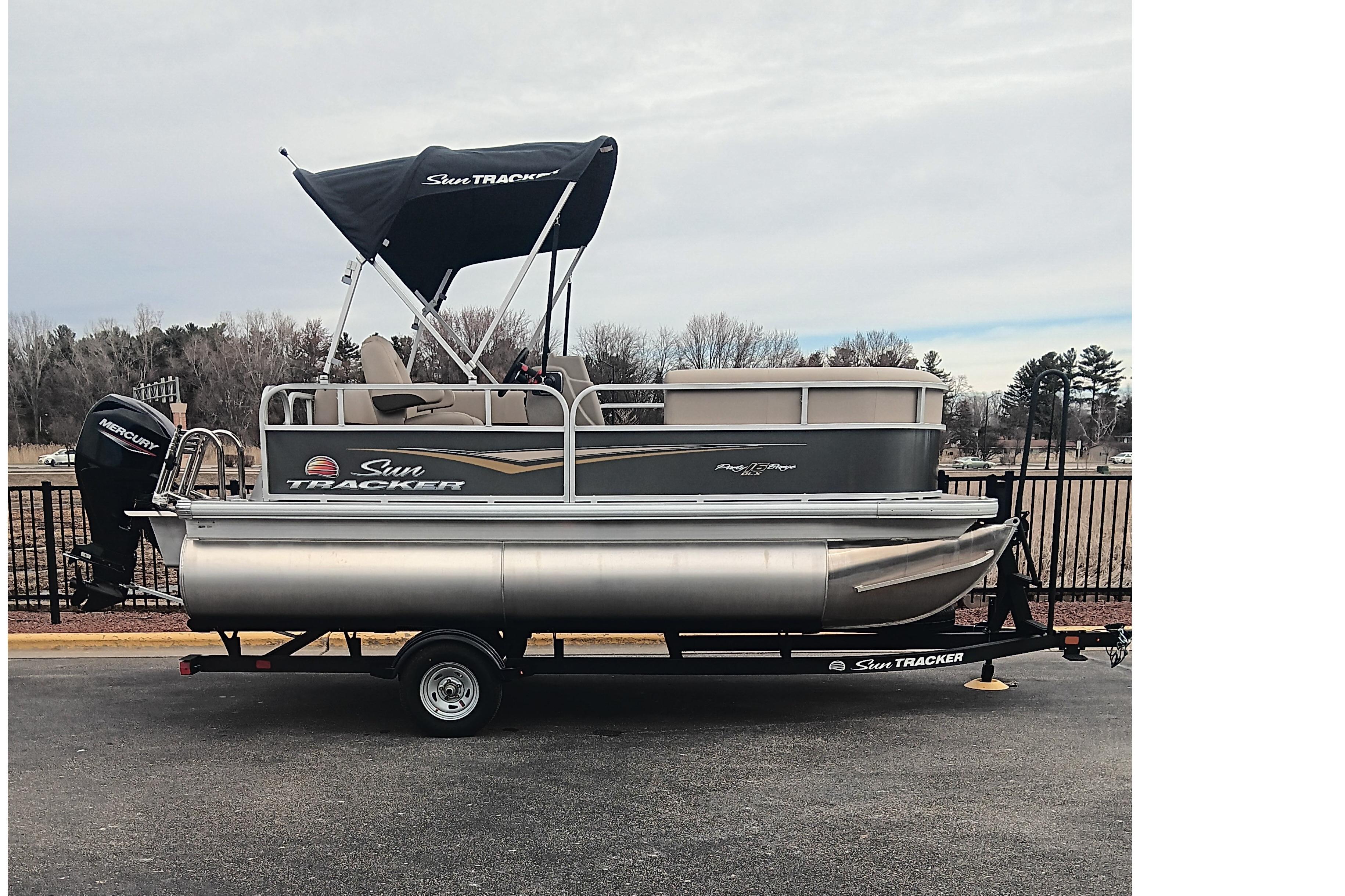 Sun Tracker Party Barge 18 DLX 2025 Sun Tracker Party Barge 18 DLX pontoon boat on trailer, parked outdoors.
