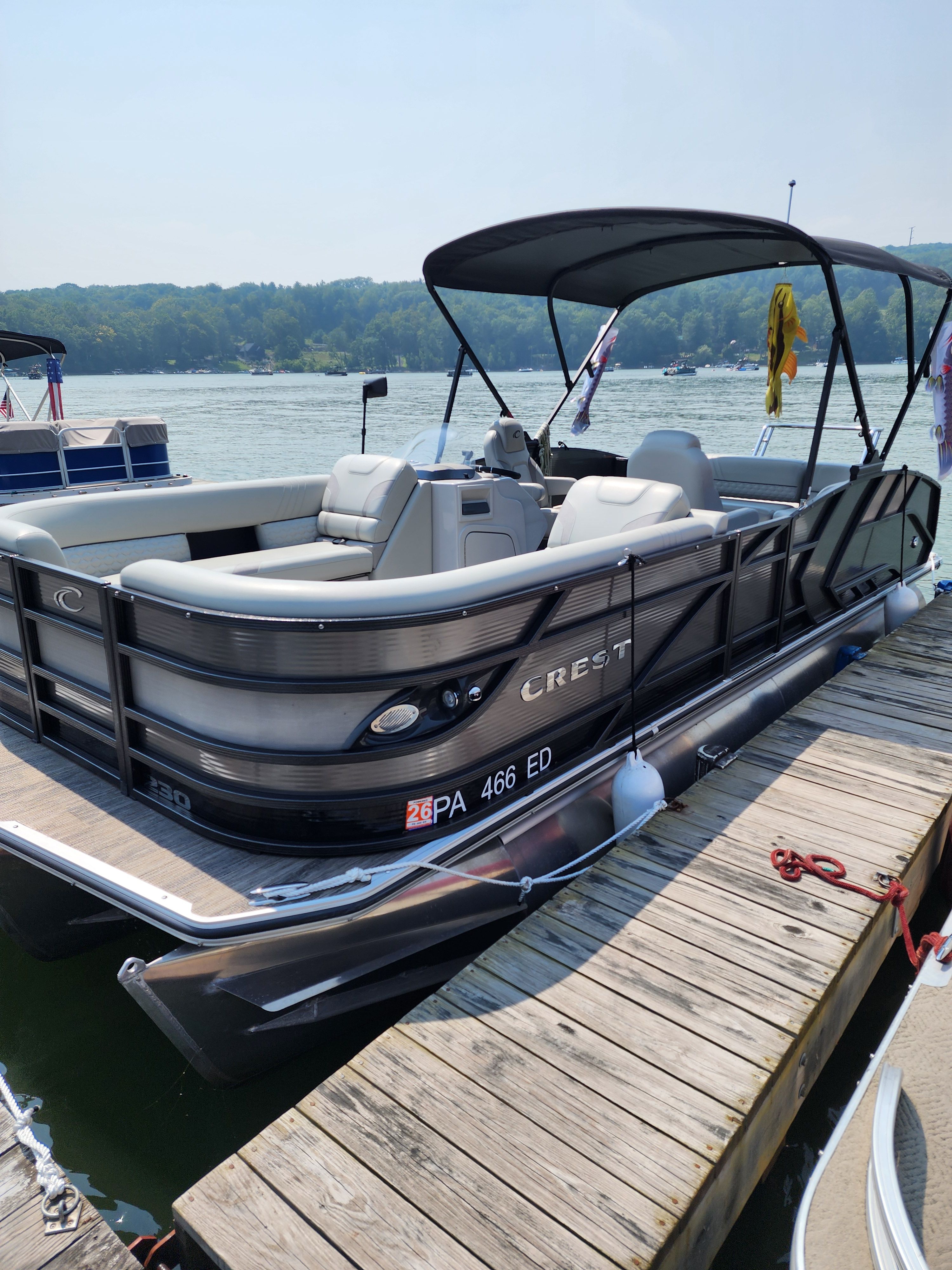 Crest LX 230 SLS 2023 Crest LX 230 SLS pontoon boat docked on a sunny day.