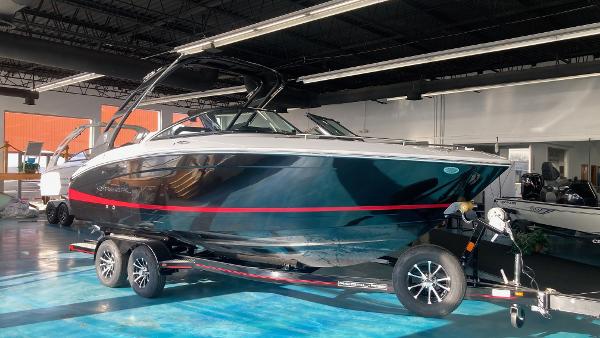 Regal LS4 2025 Regal LS4 boat on trailer in showroom, sleek black design with red accents.