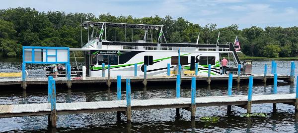 Sumerset Houseboat 64' x 14' 1989 Sumerset Houseboat 64' x 14' docked on a calm river with lush greenery.