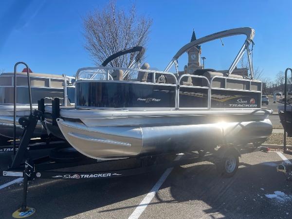 Sun Tracker Bass Buggy 16 XL Select 2025 Sun Tracker Bass Buggy 16 XL Select pontoon boat on trailer, parked outdoors.