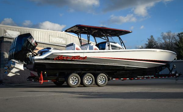 Nor-Tech 390 Sport 2025 Nor-Tech 390 Sport boat on trailer, sleek design, triple engines, parked outdoors.