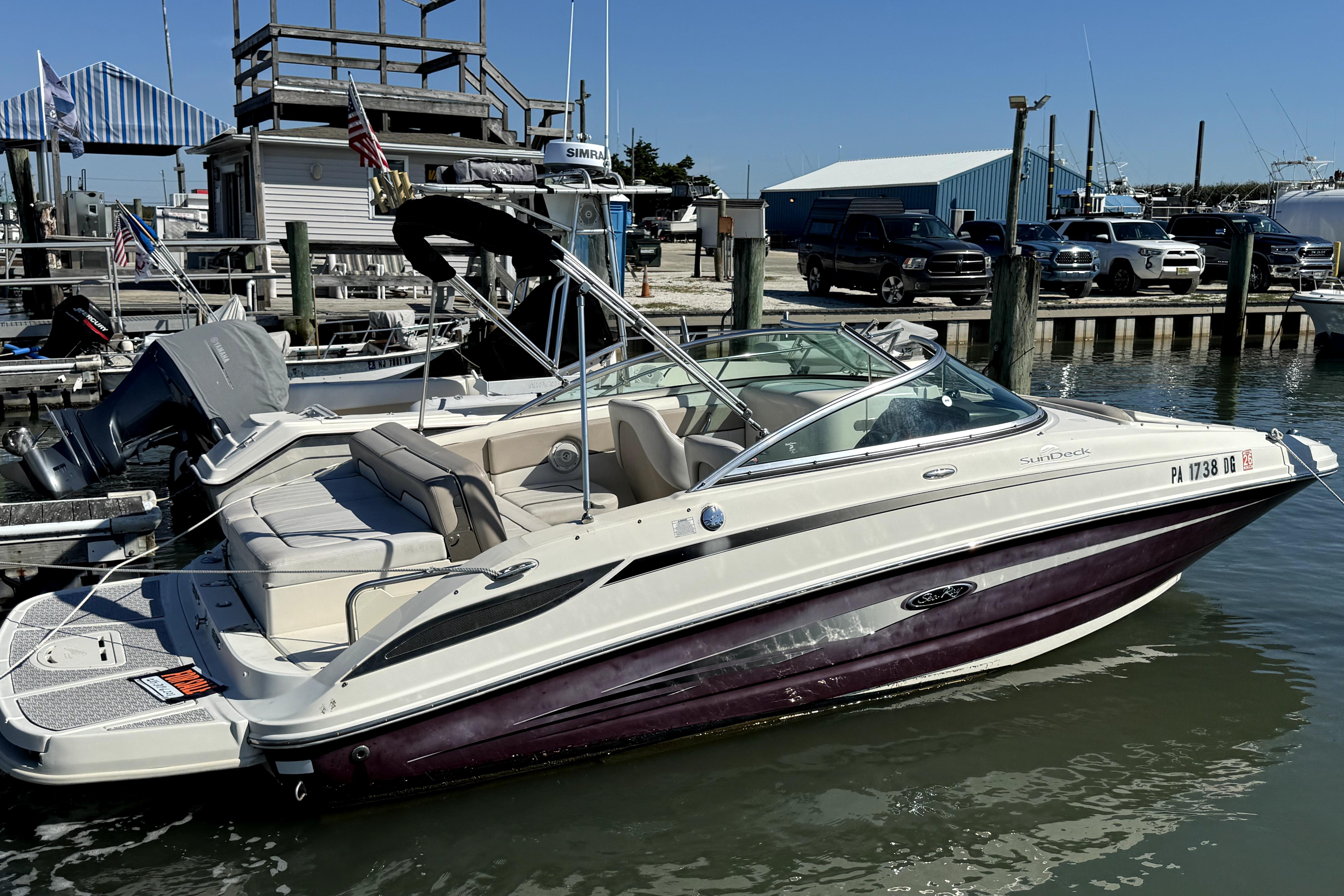 Sea Ray 220 Sundeck 2010 Sea Ray 220 Sundeck boat docked at marina under clear blue sky.