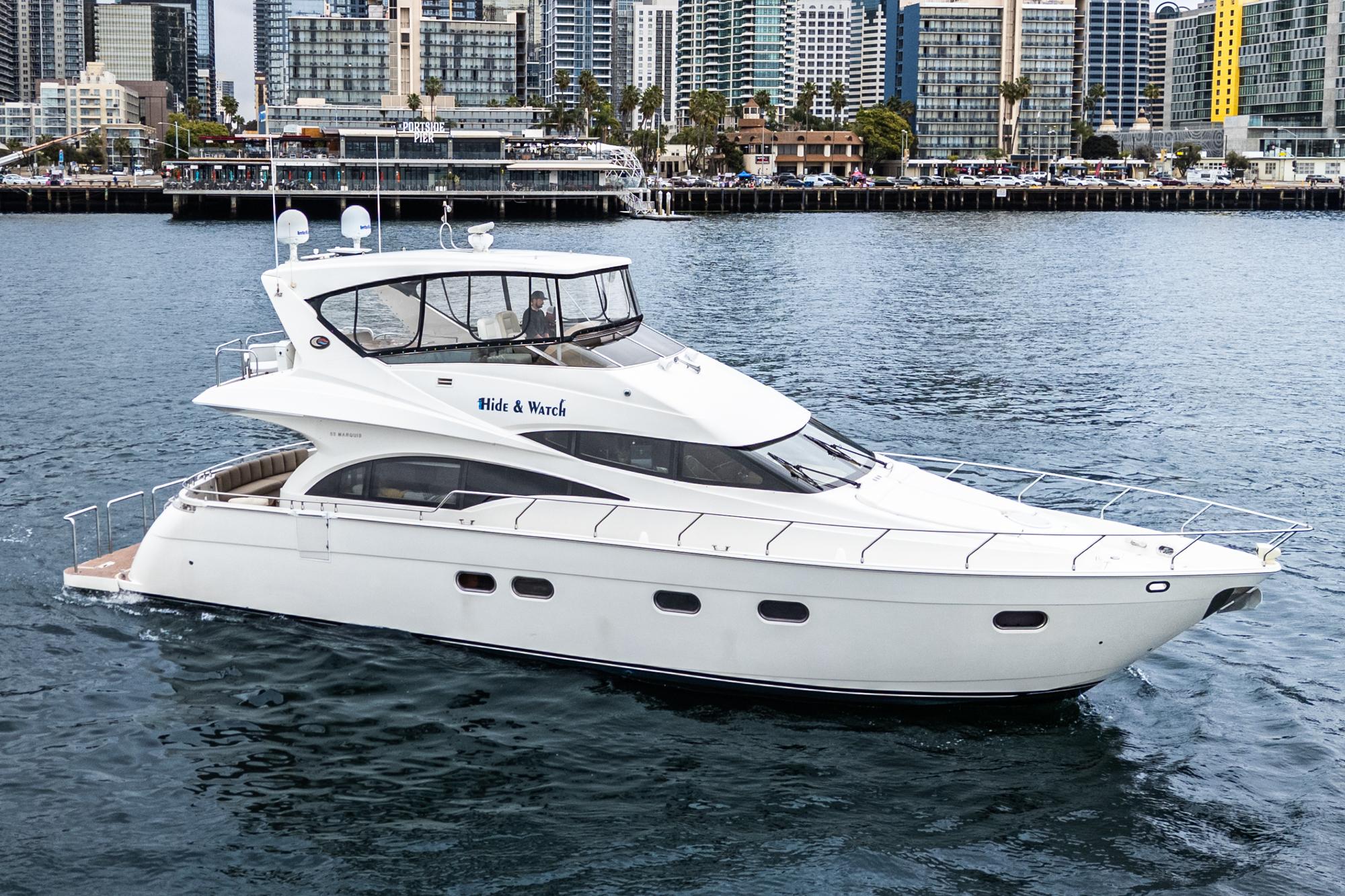 Marquis 59 Luxury 2004 Marquis 59 yacht cruising near urban waterfront skyline.