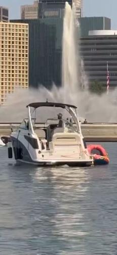 Regal 26 X 2024 Regal 26 X boat on water near cityscape and fountain.