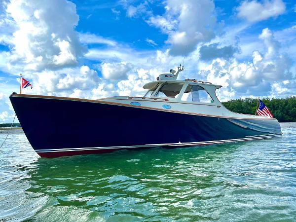Hinckley 36 Picnic Boat Hinckley 36 Picnic Boat, 1995 model, cruising on clear waters under a vibrant sky.