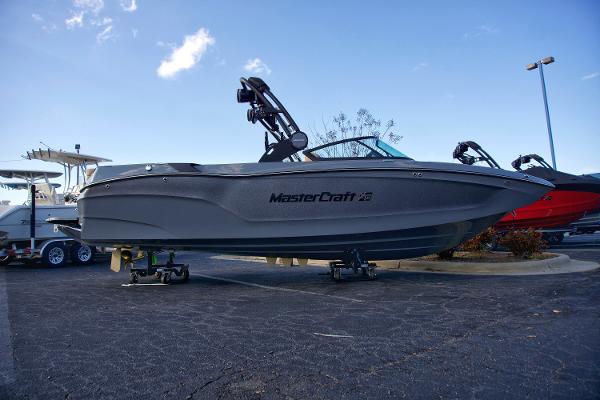 MasterCraft XT24 2025 MasterCraft XT24 boat on display in a parking lot under a clear sky.