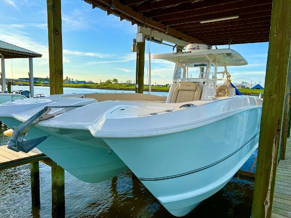 Twin Vee 340 GFX CC 2023 Twin Vee 340 GFX CC catamaran docked under a wooden shelter.