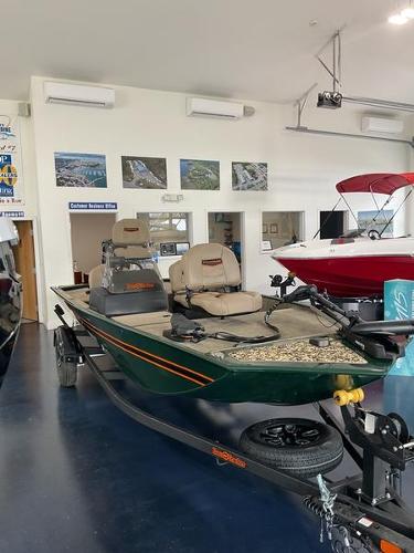 Tracker BT CLASSIC SE 2025 Tracker BT CLASSIC SE boat displayed in showroom with fishing seats and trailer.