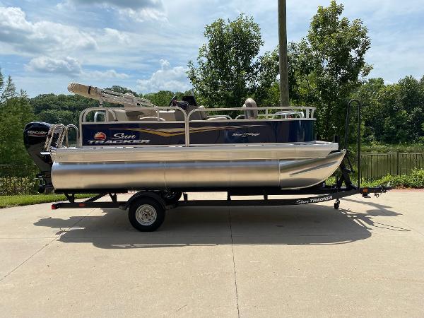 Sun Tracker Bass Buggy 16 XL Select 2025 Sun Tracker Bass Buggy 16 XL Select pontoon boat on trailer, outdoors.