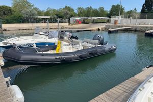 Zodiac Pro Open 650 2001 Zodiac Pro Open 650 boat docked in a marina, surrounded by calm water.