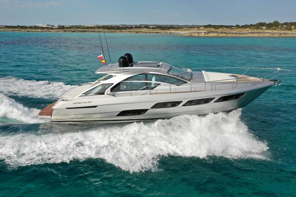 Pershing 5x 2021 Pershing 5x yacht cruising on clear blue water near a scenic coastline.