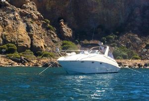 Larson Cabrio 310 2003 Larson Cabrio 310 boat anchored near rocky shoreline.