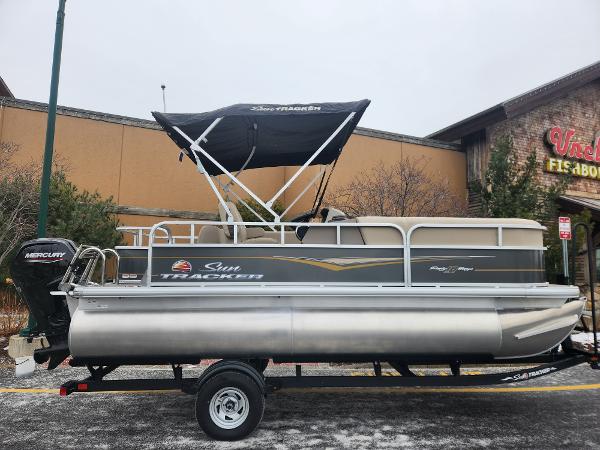 Sun Tracker Party Barge 18 DLX 2025 Sun Tracker Party Barge 18 DLX pontoon boat on trailer, outdoor display.