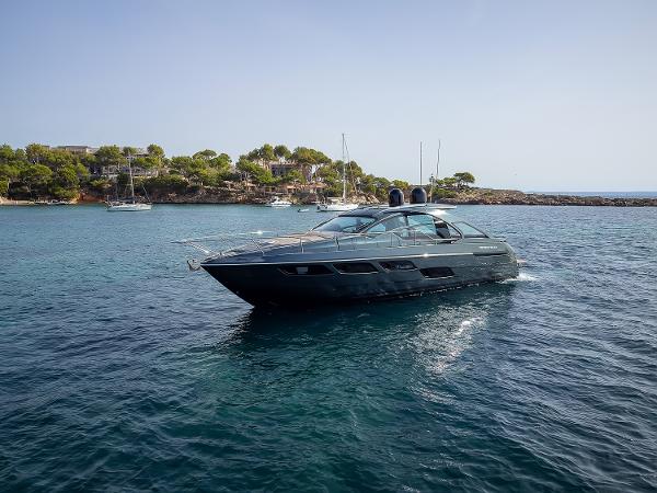 Pershing 5x 2017 Pershing 5x yacht cruising in clear blue waters near a scenic coastline.