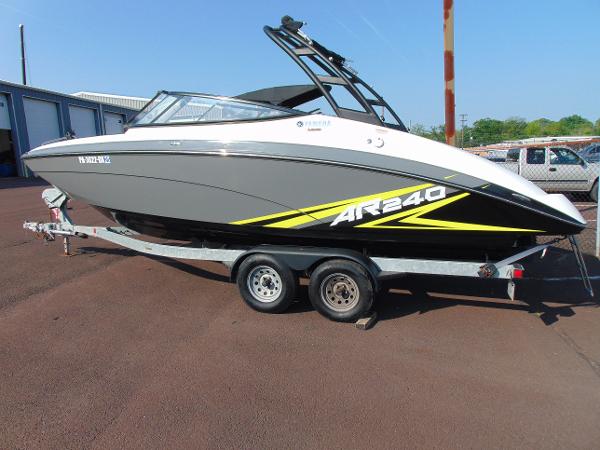 Yamaha Boats AR240 2020 Yamaha AR240 boat on trailer, gray and white with yellow accents, parked outdoors.