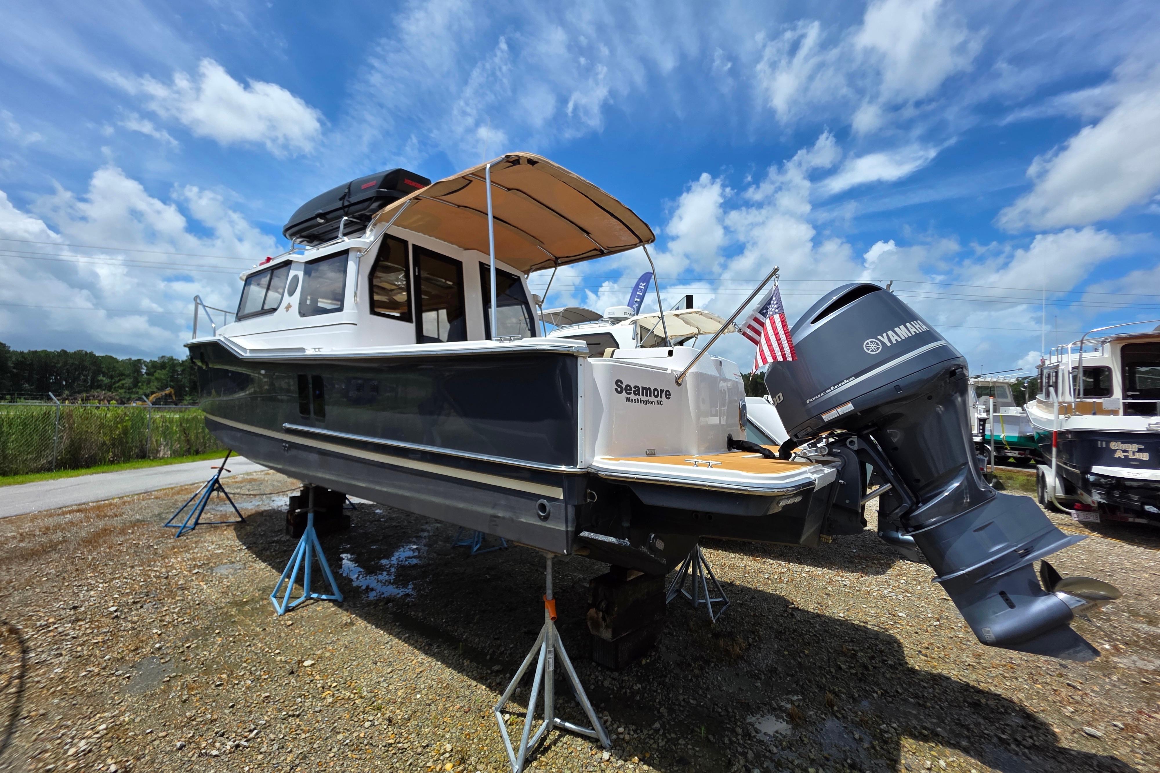 Ranger Tugs R27LE 2020 Ranger Tugs R27LE boat on stands, with Yamaha outboard motor, under a blue sky.