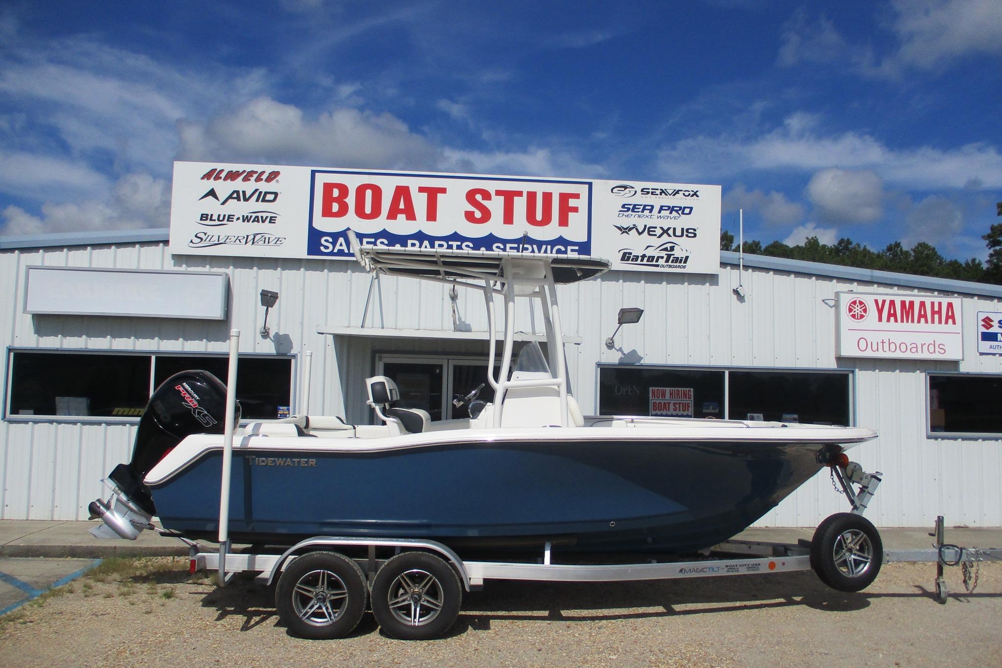 Tidewater 210 LXF 2023 Tidewater 210 LXF boat on trailer outside dealership under blue sky.