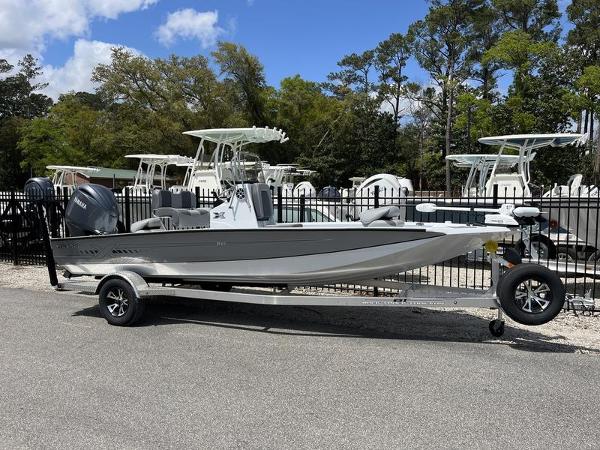 Xpress H20B 2025 Xpress H20B boat on trailer, parked outdoors with trees and blue sky.