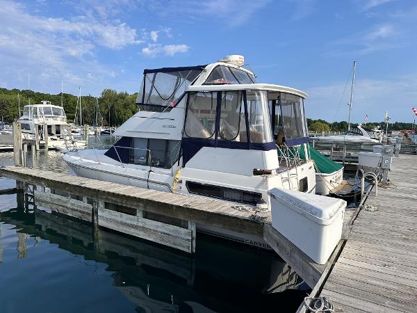 Carver 33 Aft Cabin 1993 Carver 33 Aft Cabin yacht docked at a marina under a clear blue sky.