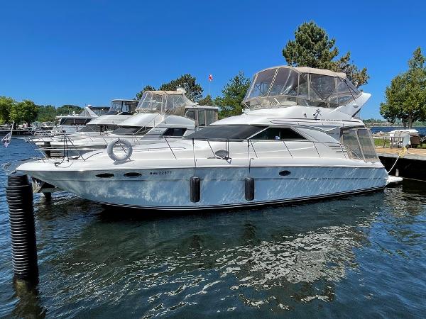 Sea Ray 400 Sedan Bridge 1996 Sea Ray 400 Sedan Bridge yacht docked in a marina under clear blue skies.