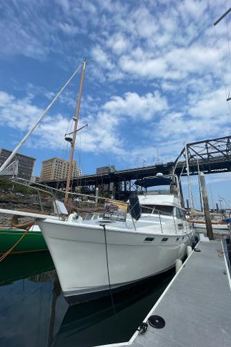Bayliner 3888 Motoryacht 1989 Bayliner 3888 yacht docked under a blue sky with bridge in background.