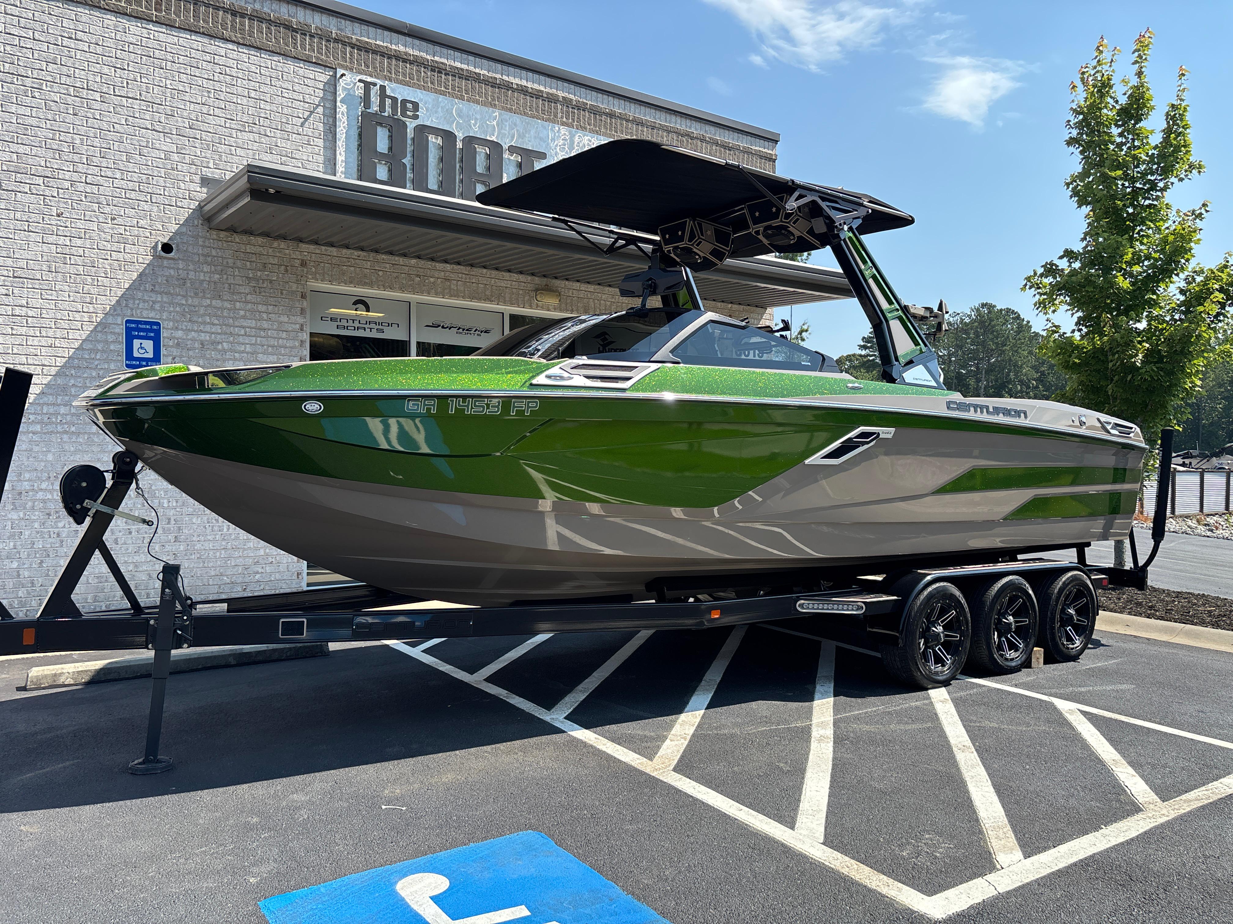Centurion Ri265 2023 Centurion Ri265 boat in green and gray on a trailer outside a dealership.
